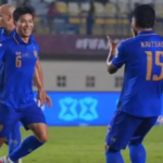 Timnas Thailand memastikan tiket ke final FIFA ASEAN Cup 2026 setelah menaklukkan Vietnam dengan skor 2-0 pada matchday kedua Grup B di Stadion Si Jalak Harupat, Soreang, Kabupaten Bandung, Selasa (29/9/2026) malam. Dua gol kemenangan Thailand dicetak Sarach Yooyen pada babak pertama dan Chaiyaphon Otton pada masa injury time. Hasil ini sekaligus mengakhiri perlawanan Vietnam yang tampil dominan dalam penguasaan bola, tetapi kesulitan menembus pertahanan solid Gajah Perang. Vietnam yang mengenakan kostum putih-putih langsung mengambil inisiatif serangan sejak awal pertandingan. Sementara itu, Thailand memilih bermain lebih sabar dan menunggu kesempatan untuk melancarkan serangan balik. Strategi tersebut membuahkan hasil. Thailand berhasil membuka keunggulan melalui tendangan keras Sarach Yooyen dari luar kotak penalti yang mengarah tepat ke gawang Vietnam. Sarach Yooyen Buka Keunggulan Thailand Setelah unggul 1-0, Thailand semakin percaya diri mengembangkan permainan. Dengan dukungan pemain berpengalaman seperti Manuel Bihr, Supachai Chaided, dan Chanathip Songkrasin, tim asuhan Anthony Hudson mampu menjaga keseimbangan antara pertahanan dan serangan. Thailand tidak terburu-buru membangun serangan. Mereka lebih mengutamakan ketepatan dalam memanfaatkan ruang dan menunggu celah di pertahanan lawan. Di sisi lain, Vietnam terus berusaha menguasai jalannya pertandingan. The Golden Stars Warriors beberapa kali membangun serangan, tetapi rapatnya barisan pertahanan Thailand membuat peluang mereka belum menghasilkan gol. Hingga wasit meniup peluit tanda berakhirnya babak pertama, skor tetap 1-0 untuk keunggulan Thailand. Vietnam Gagal Membongkar Pertahanan Gajah Perang Memasuki babak kedua, Vietnam meningkatkan intensitas serangan. Pelatih Kim Sang Sik memasukkan Do Hoang Hen, Williams Minh Hoang, dan Nguyen Hoang Duc untuk menambah daya gedor timnya. Pergantian tersebut membuat Vietnam semakin aktif menekan pertahanan Thailand. Namun, hingga menit ke-70, belum ada gol penyeimbang yang berhasil diciptakan. Vietnam terus mencari celah, tetapi belum menemukan cara efektif untuk menembus organisasi pertahanan yang dibangun Anthony Hudson. Situasi semakin sulit bagi Vietnam setelah lini depan mereka kehilangan sejumlah opsi serangan. Absennya Nguyen Xuan Son akibat cedera membuat variasi serangan berkurang, sedangkan Nguyen Dinh Bac mendapat pengawalan ketat sehingga tidak leluasa memperoleh ruang tembak. Thailand Kunci Kemenangan pada Injury Time Memasuki 15 menit terakhir pertandingan, Thailand mengubah pendekatan permainan dengan lebih berani menguasai bola dan membangun serangan. Sejumlah peluang berhasil diciptakan, sementara pertahanan Vietnam mulai menghadapi tekanan yang semakin besar. Vietnam tetap berusaha mengejar ketertinggalan hingga memasuki masa tambahan waktu. Namun, upaya tersebut justru berujung pada gol kedua Thailand. Chaiyaphon Otton mencetak gol pada menit ke-90+3 sekaligus memastikan kemenangan 2-0 bagi Gajah Perang. Hasil tersebut mengantarkan Thailand melaju ke final FIFA ASEAN Cup 2026. Sementara itu, Vietnam harus menerima kekalahan setelah gagal memaksimalkan dominasi permainan dan sejumlah peluang yang diperoleh sepanjang pertandingan. Susunan Pemain Thailand vs Vietnam Thailand: Saranon Anuin (PG); Nattaping Sayriya, Manuel Bihr, Kritsada Kaman; Sarach Yooyen, Peeradol Chamrasamee, Nicholas Mickleson, Suphanan Bureerat; Kakana Khamyok, Supachai Chaided, Chanathip Songkrasin. Vietnam: Le Giang Patrick (PG); Le Ngoc Bao, Nguyen Adou Leygley Minh, Bui Hoang Viet Anh; Cao Pendant Quang Vinh, Le Pham Thanh Long, Vo Hoang Minh Khoa, Phan Tuan Tai; Nguyen Tai Loc, Nguyen Dinh Bac, Truong Tien Anh.