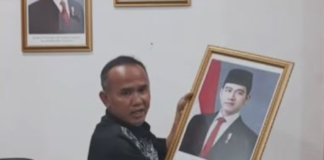 Wakil Ketua DPRD Kota Sukabumi Rojab Asy'ari menurunkan foto Gibran Rakabuming Raka dari ruang kerjanya.